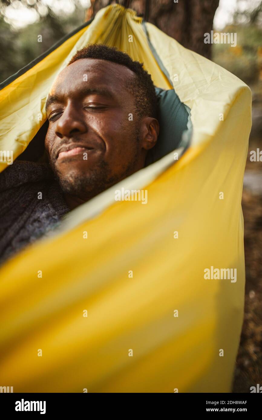 Man sleeping in hammock at forest Stock Photo