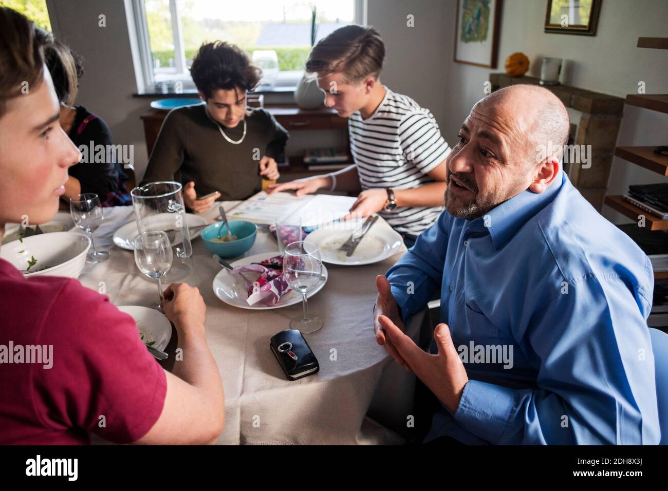 Friends and family talking at dining table in dinner party Stock Photo