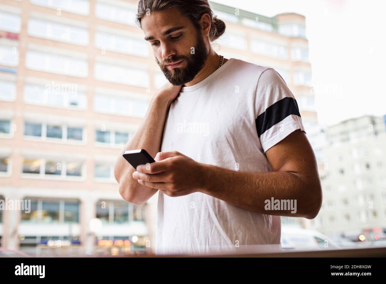 Man using smart phone while walking in city Stock Photo