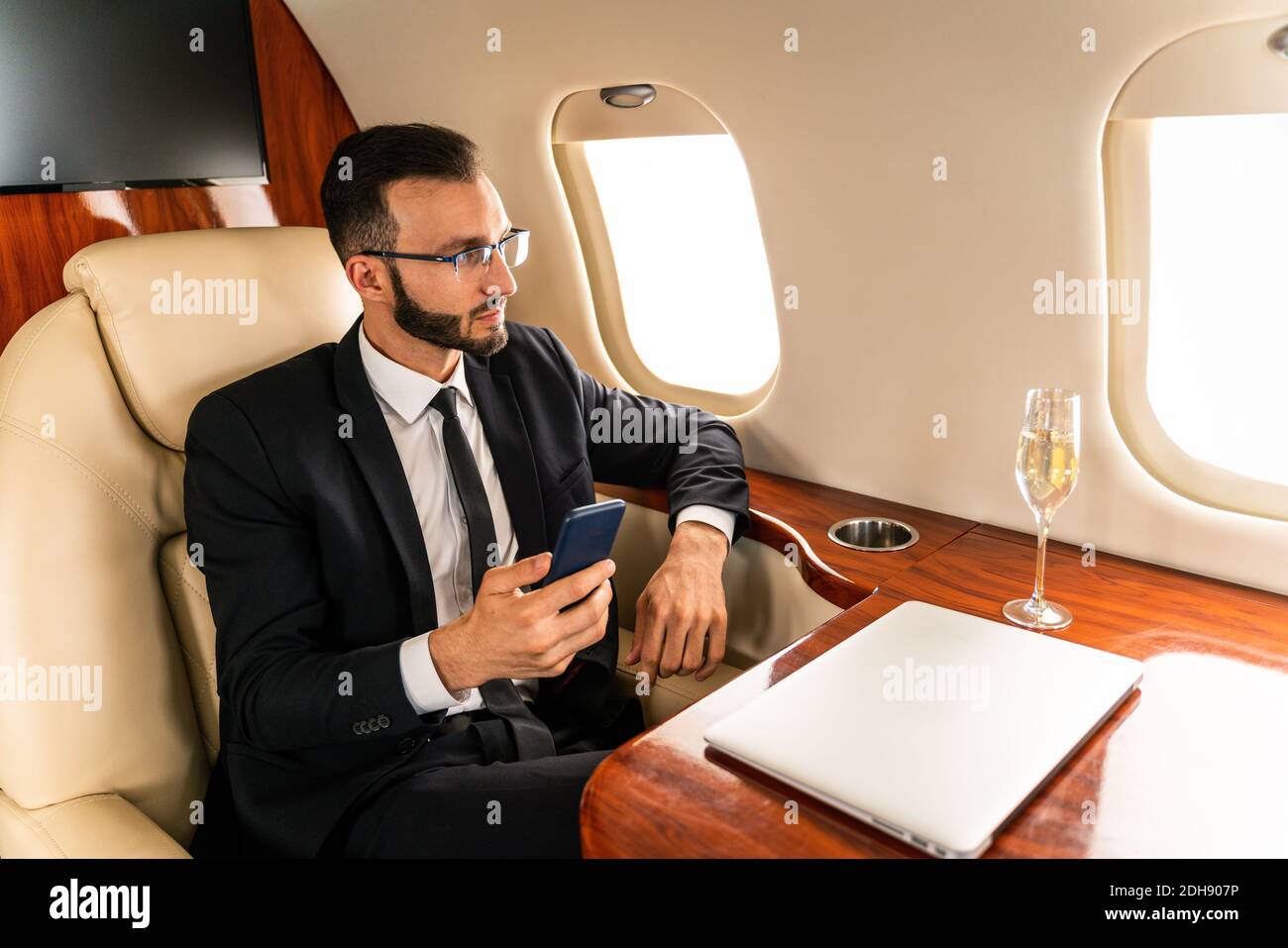 Handsome businessman wearing elegant suit flying on exclusive private
