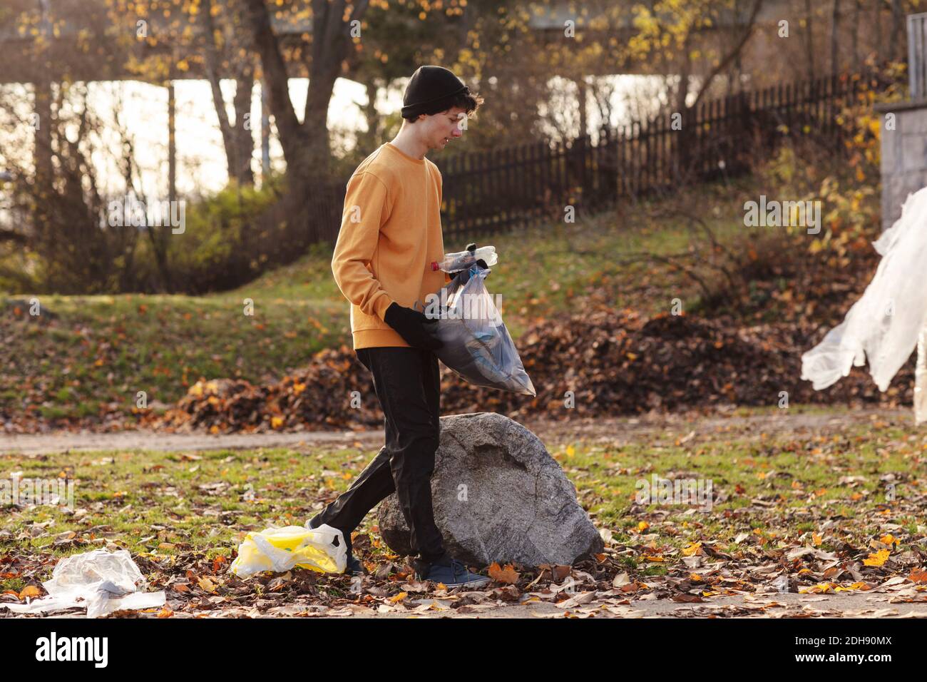 Male volunteer collecting garbage while walking in park Stock Photo