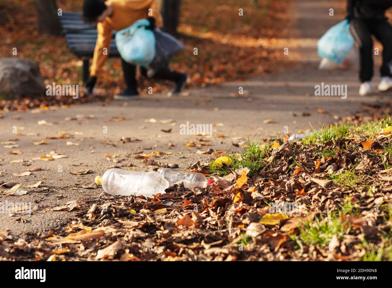 Young male volunteers plogging on footpath by public park Stock Photo