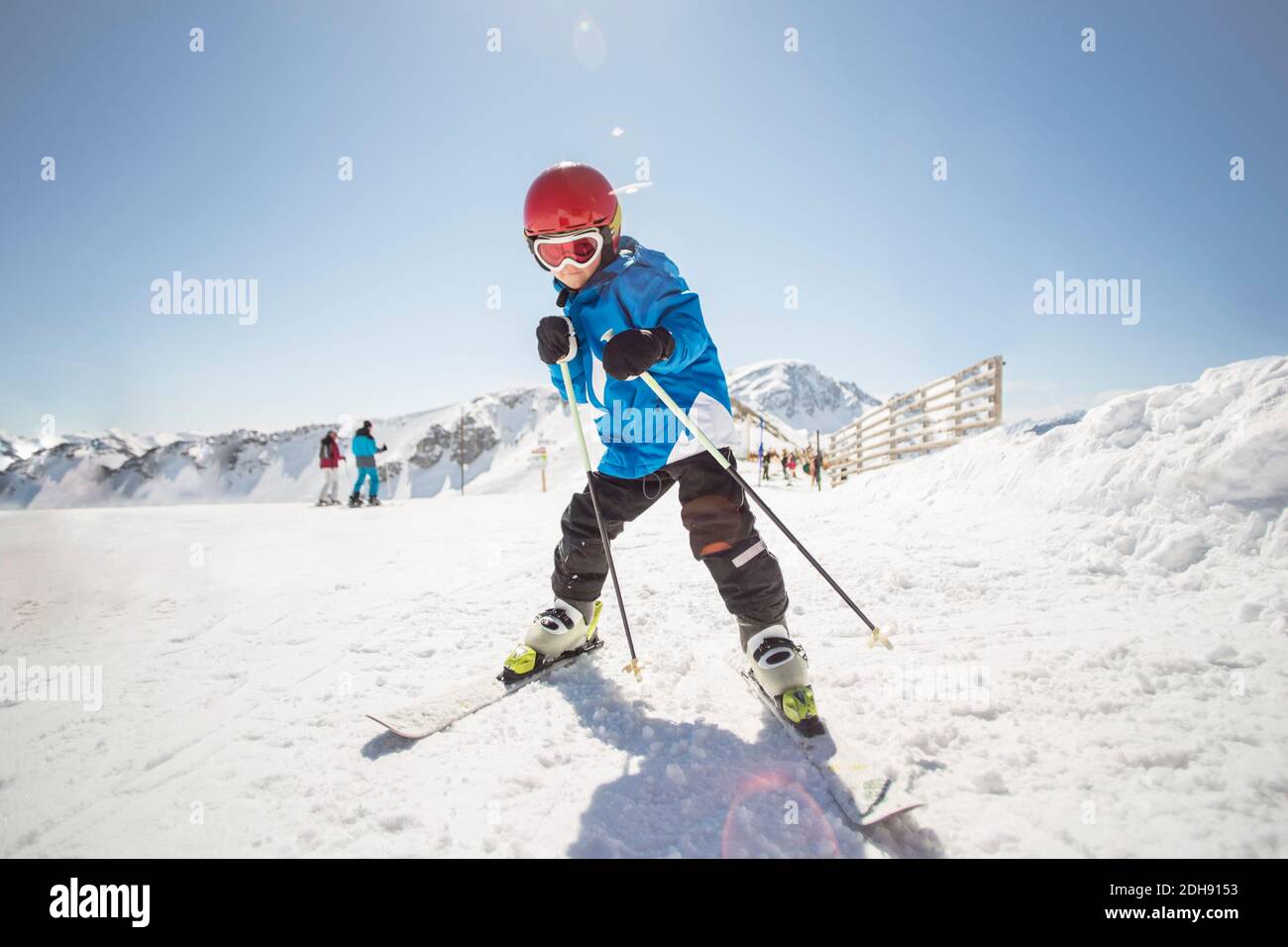 Full length of boy skiing on snow covered field against clear sky Stock Photo