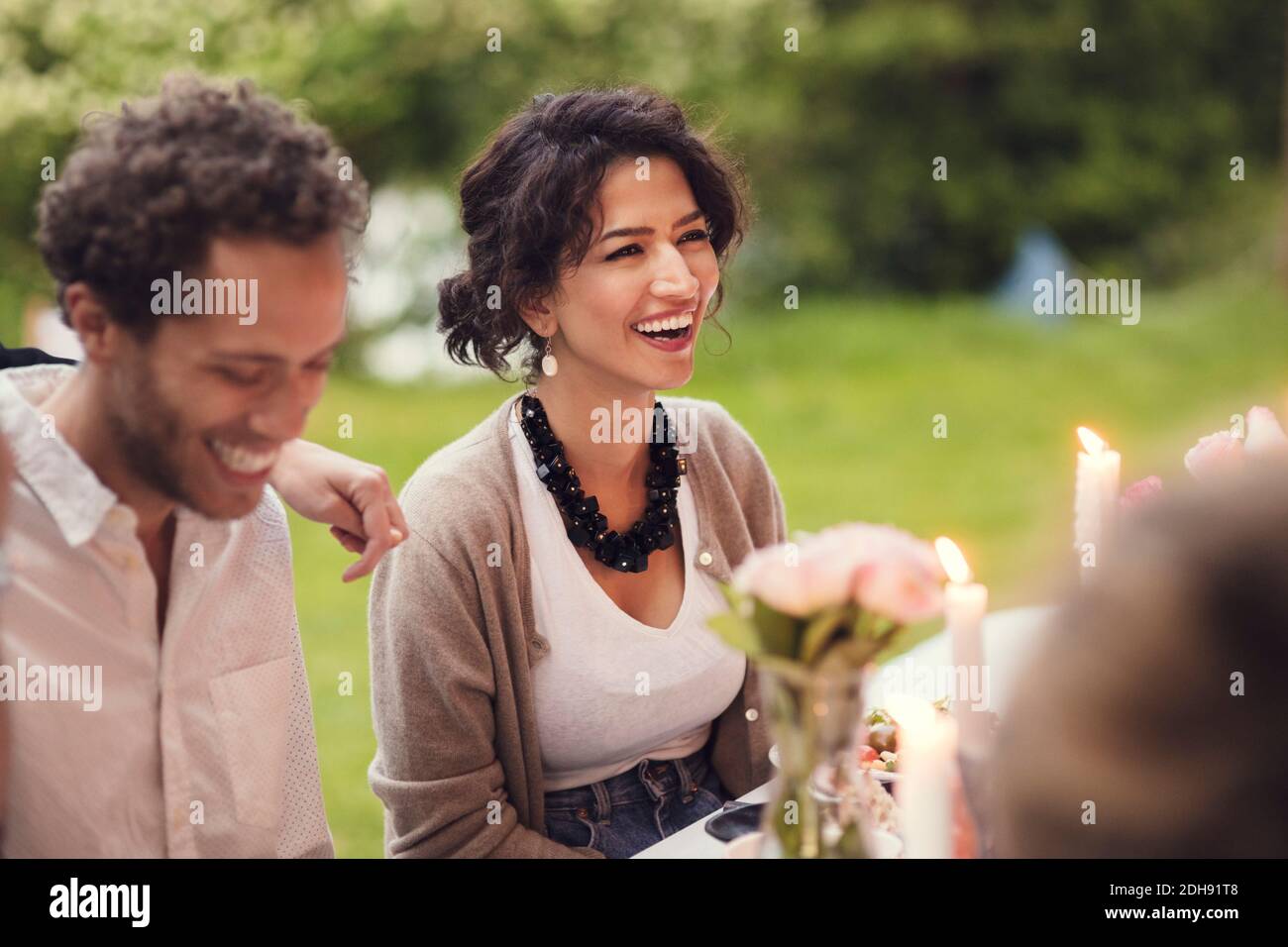 Happy friends sitting at table during garden party Stock Photo
