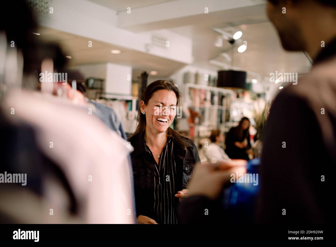 Happy woman talking to male friend in store Stock Photo