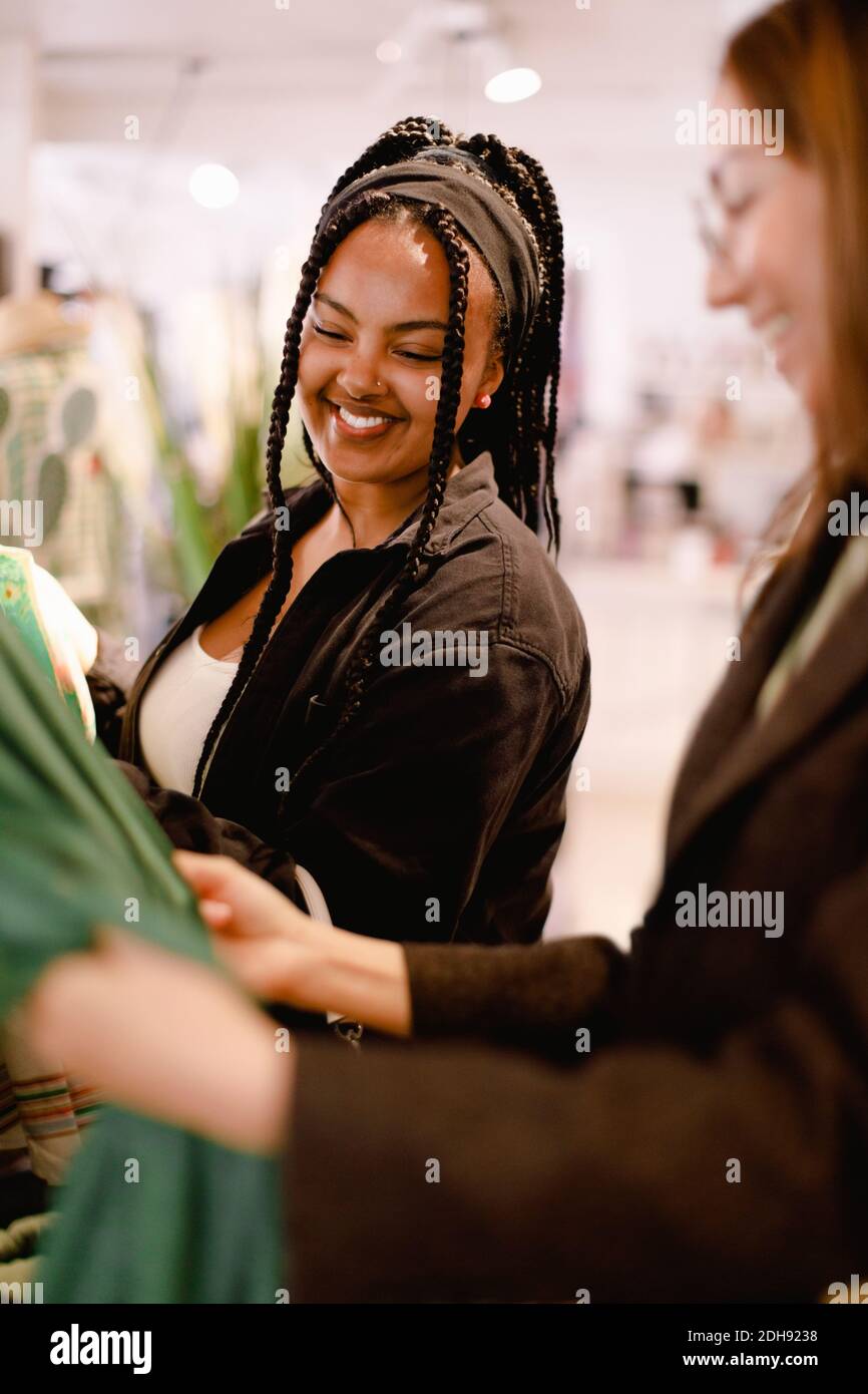 Smiling friends talking while standing at store Stock Photo