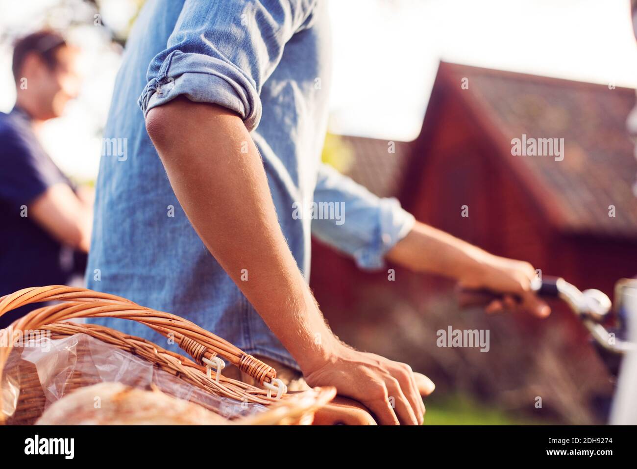 Midsection of man with bicycle at backyard Stock Photo