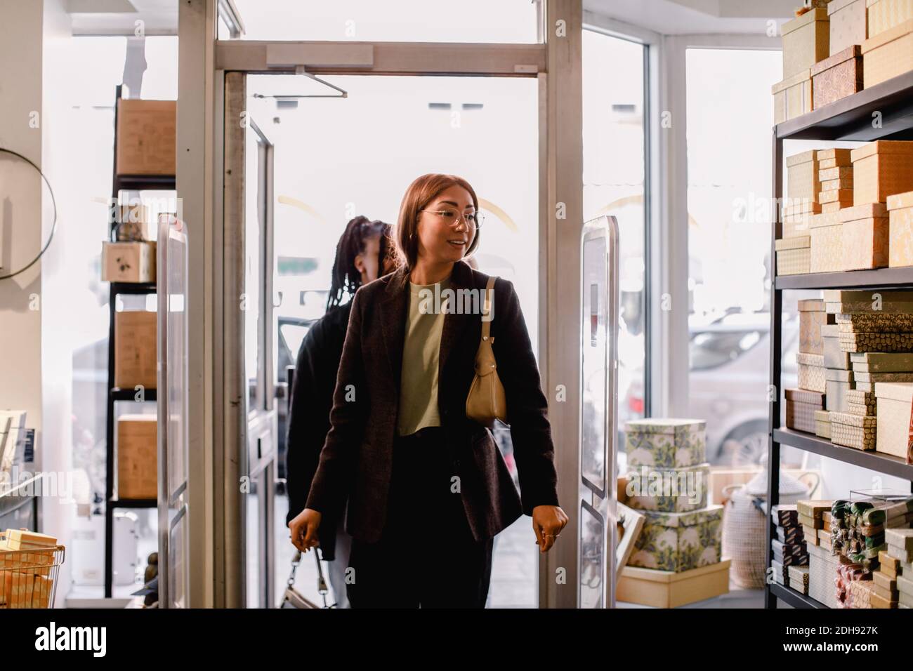 Smiling female friends entering retail store Stock Photo