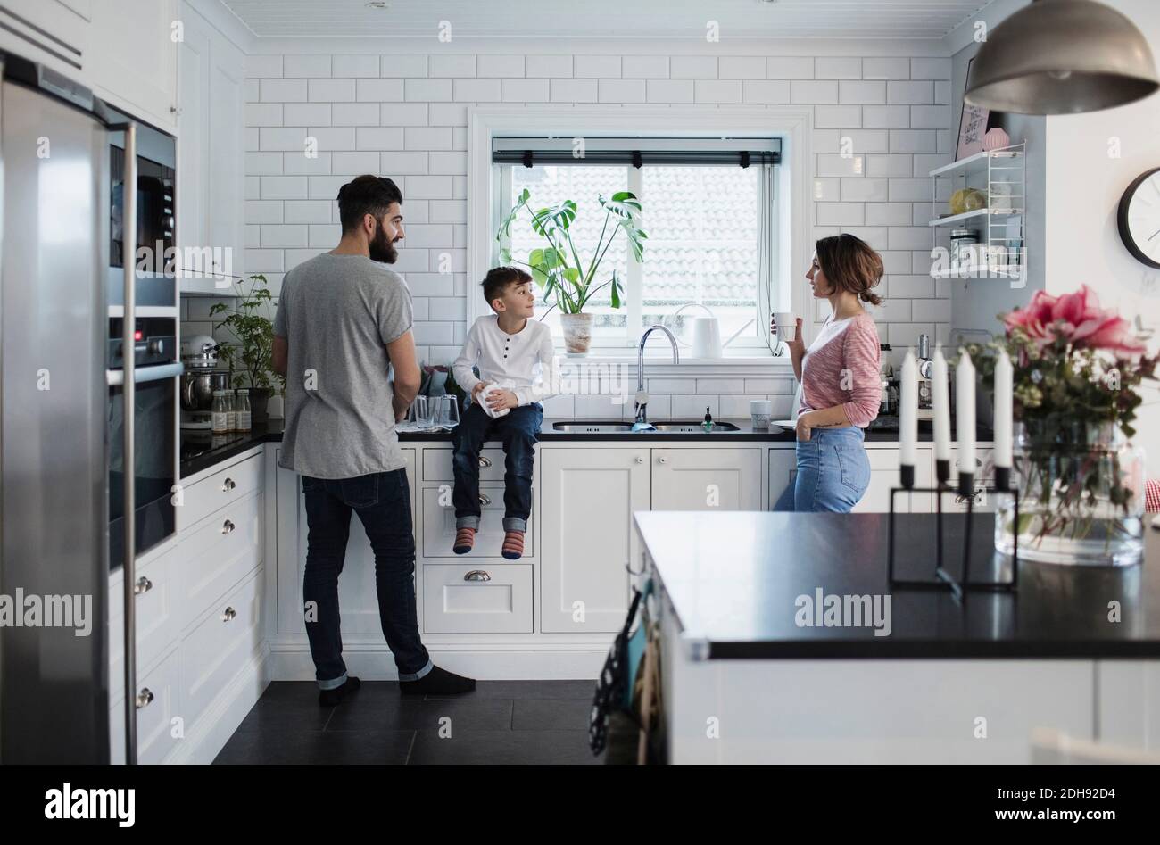 Father and mother with son in kitchen at home Stock Photo