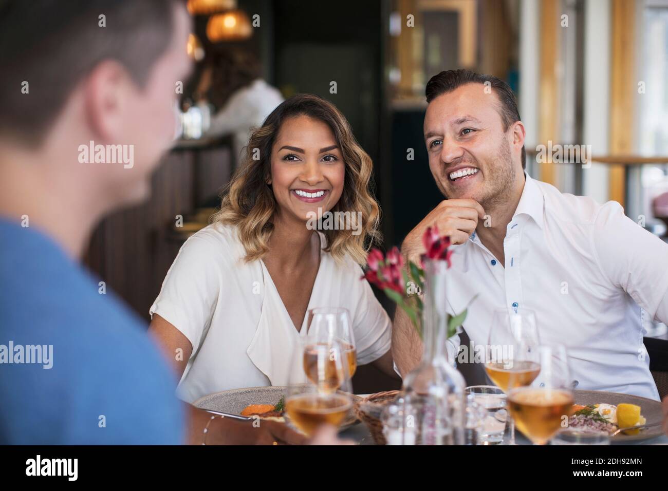 Cheerful colleagues looking at businessman during lunch at restaurant Stock Photo