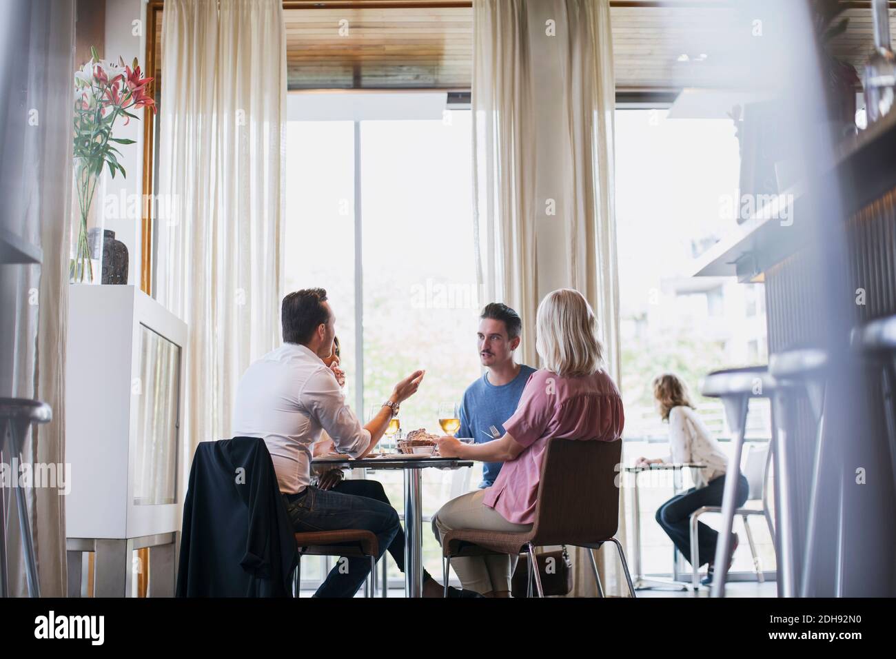 Business colleagues talking while eating lunch during meeting at restaurant Stock Photo