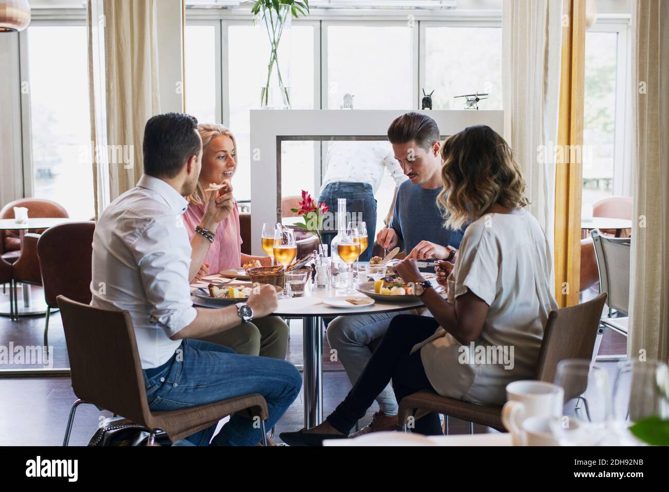 Business friends sitting at restaurant during lunch Stock Photo