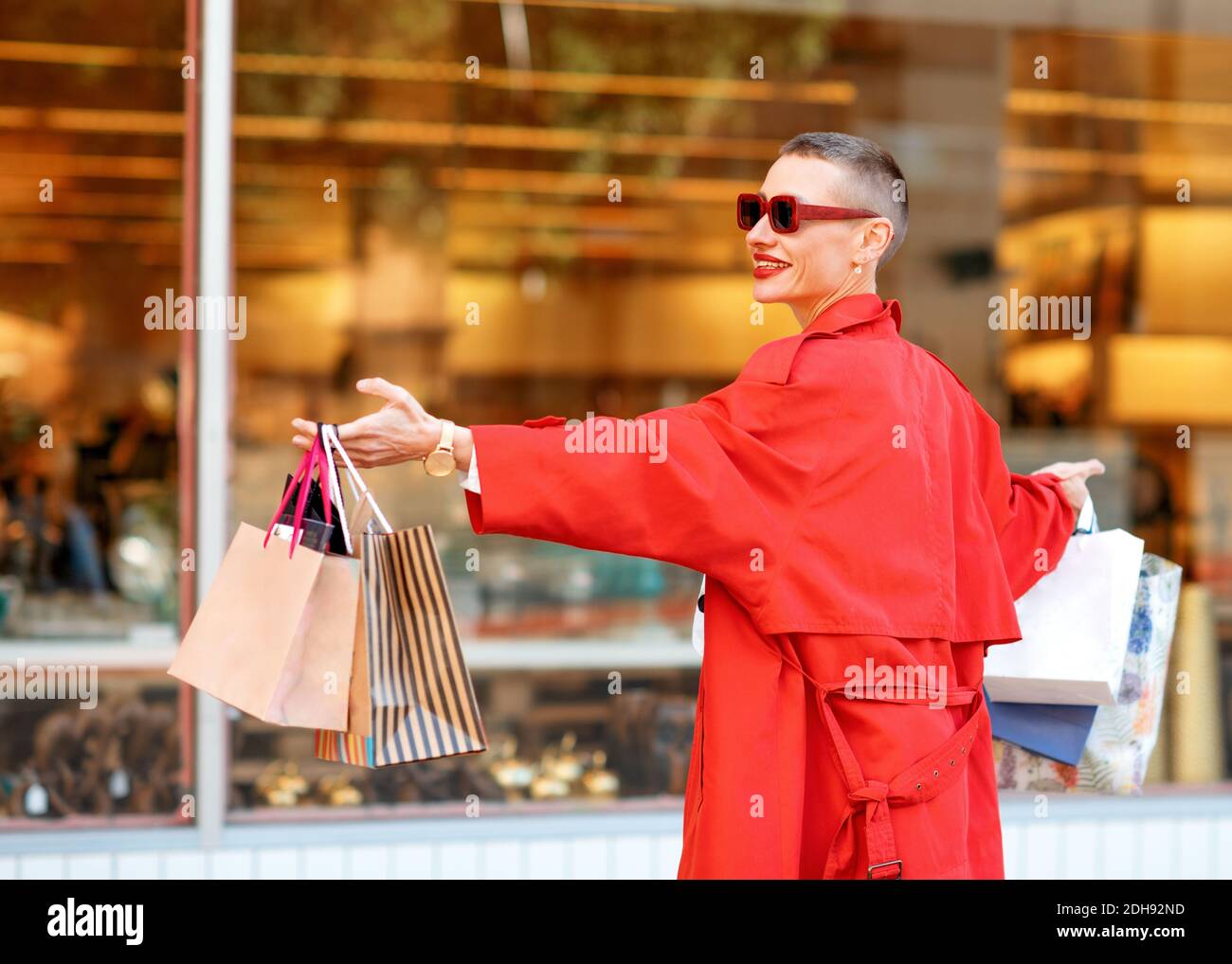 happy woman in red coat dancing in the street in the city after ...