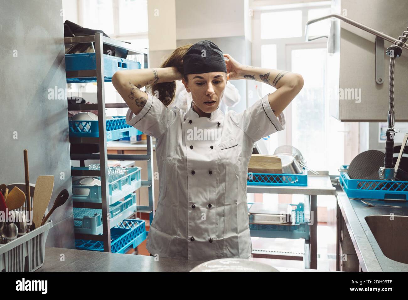 Female chef wearing hat in commercial kitchen Stock Photo Alamy