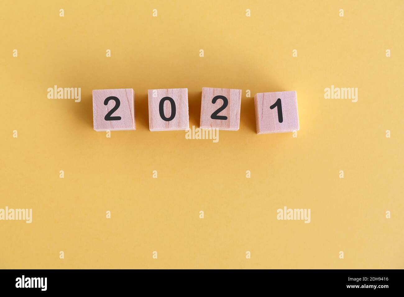 Number 2021 on wood block New Year concept yellow background Stock Photo