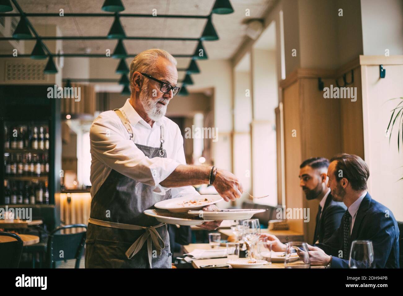 Waiter holding plates in restaurant Stock Photo Alamy