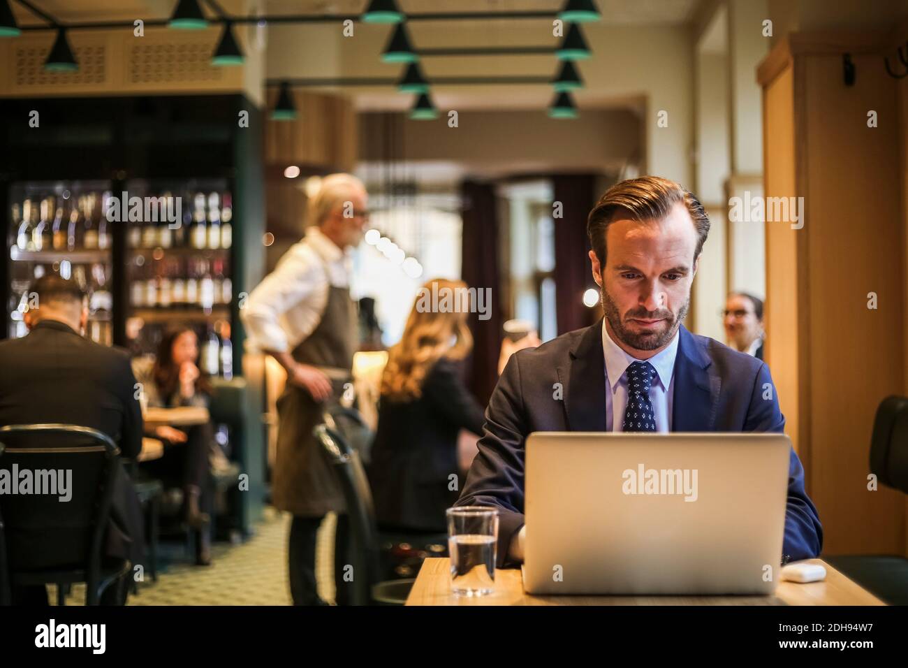 Businessman using laptop while sitting in restaurant Stock Photo