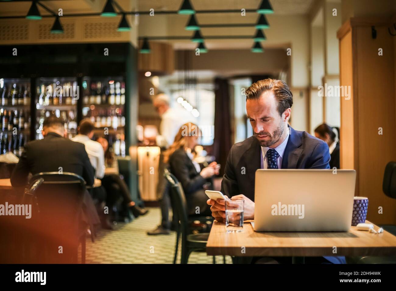 Businessman using mobile phone while sitting in restaurant Stock Photo