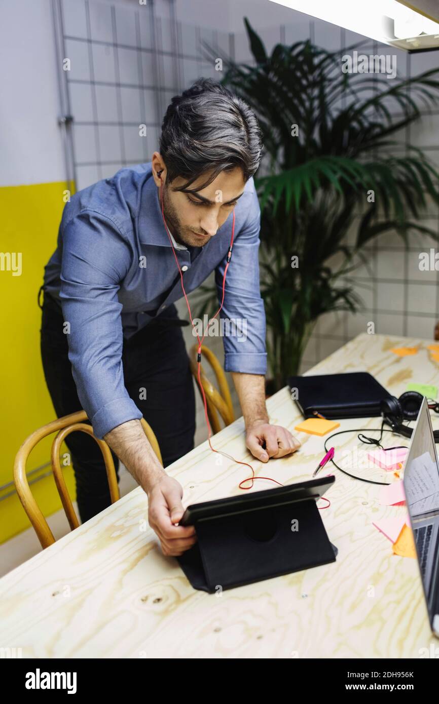 Young man using digital tablet at desk in creative office Stock Photo