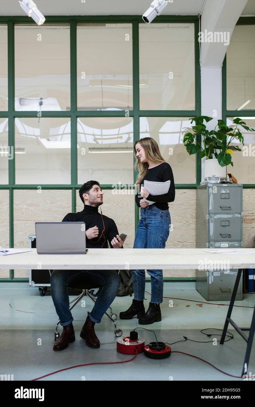 Two colleagues talking at desk in office Stock Photo