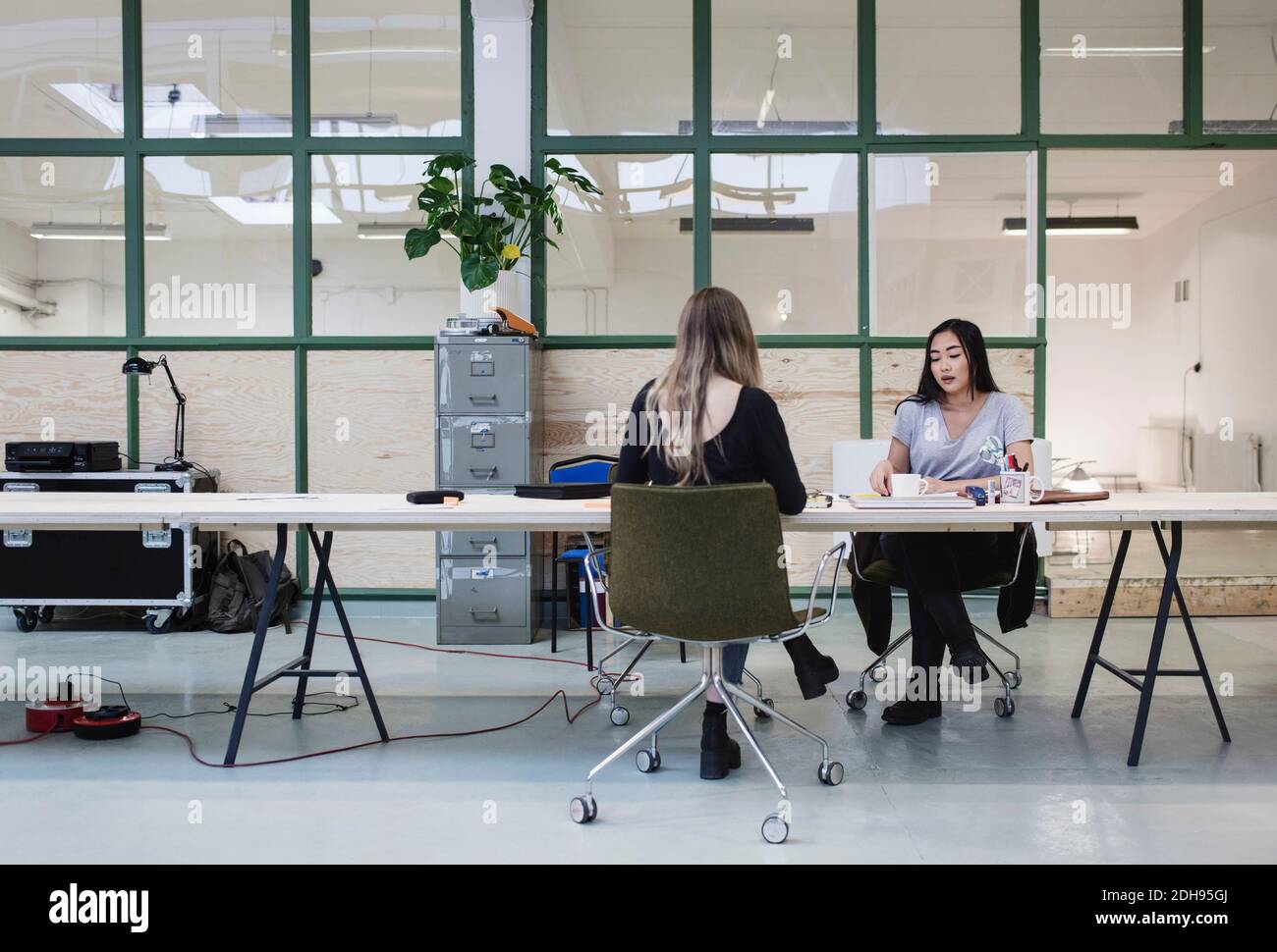 Two women working at desk in creative office Stock Photo