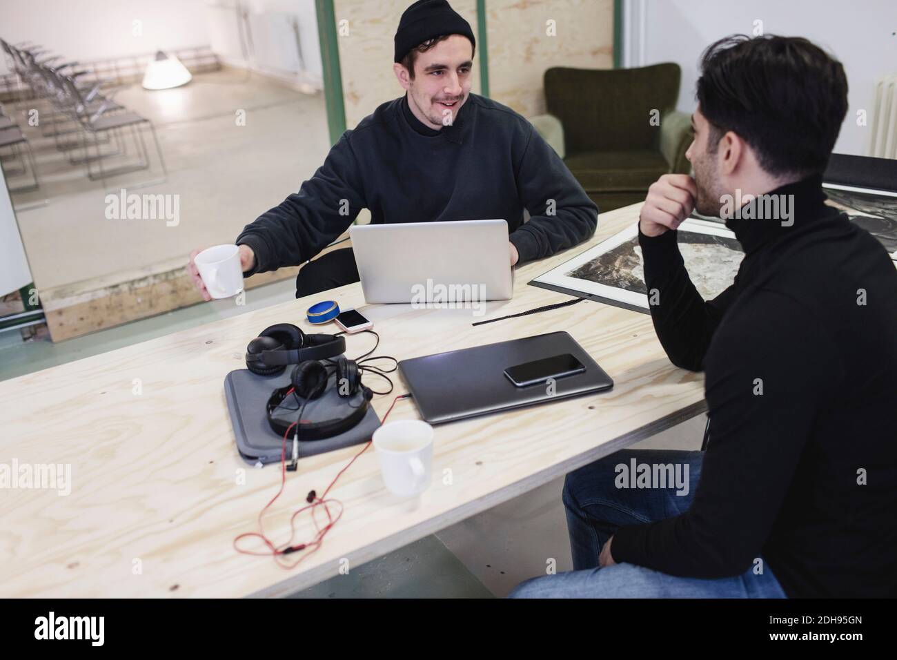 Two men discussing at desk in creative office Stock Photo