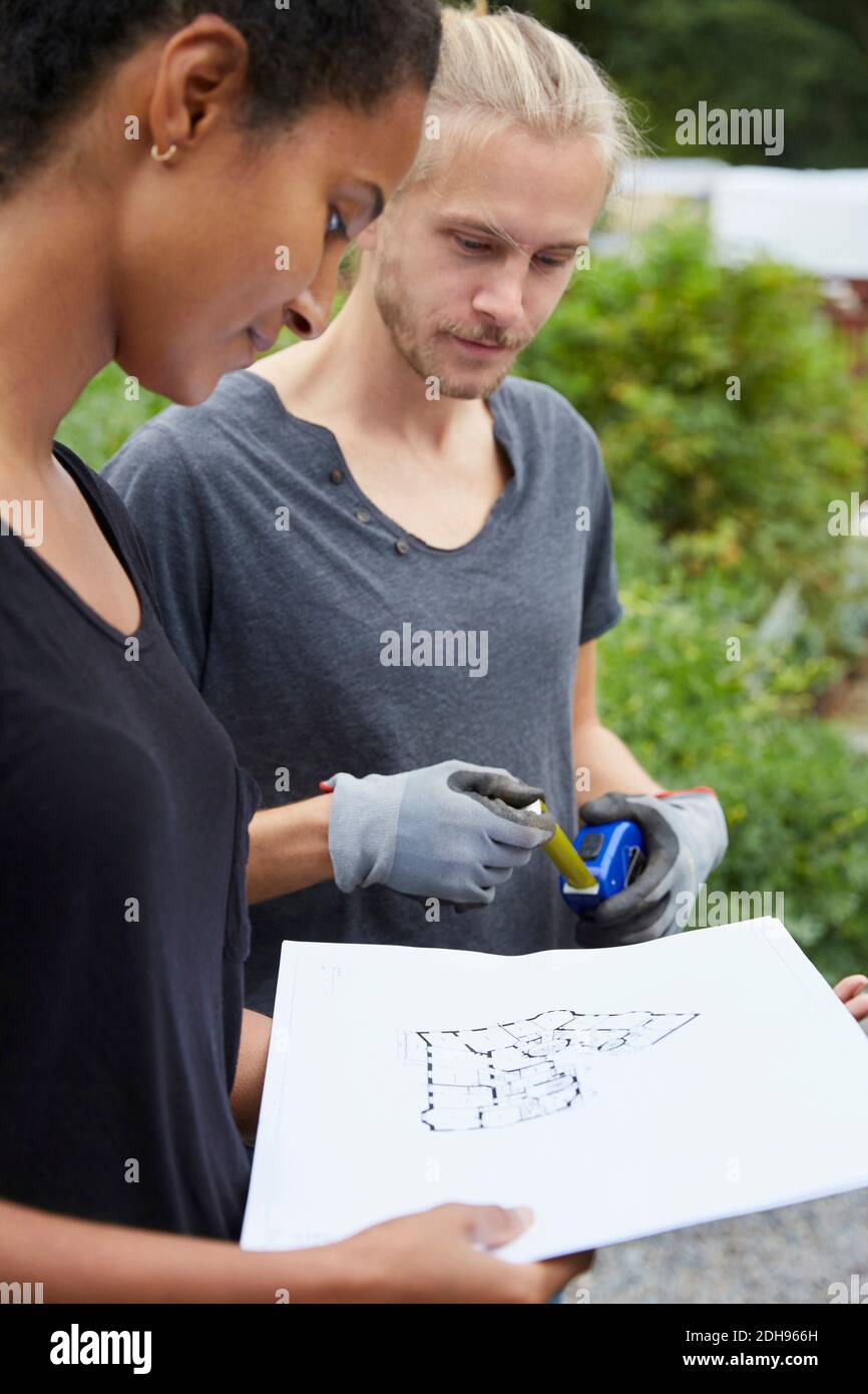 Garden architects looking at blueprint at yard Stock Photo