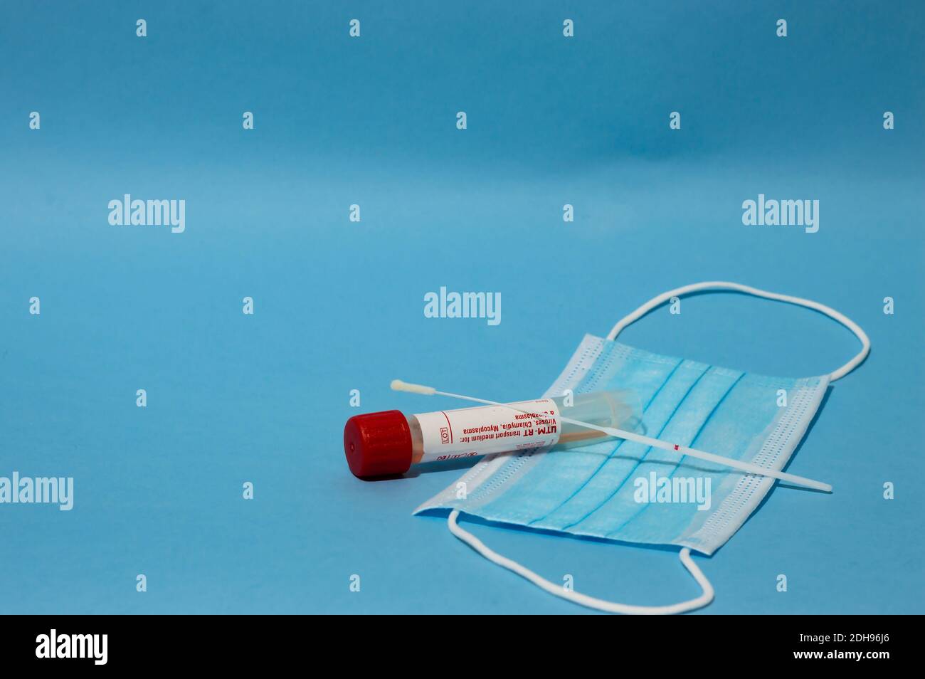 Medical equipment against coronavirus - covid test with tampoon, syringe with vaccines and medical mask on blue background with empty copy space area Stock Photo