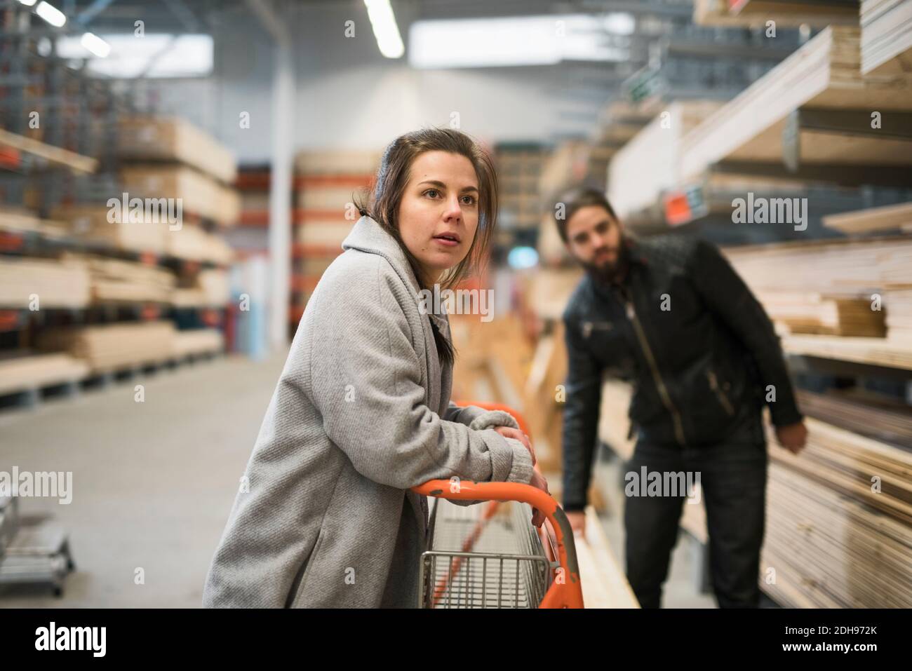 Couple looking away while standing in hardware store warehouse Stock Photo