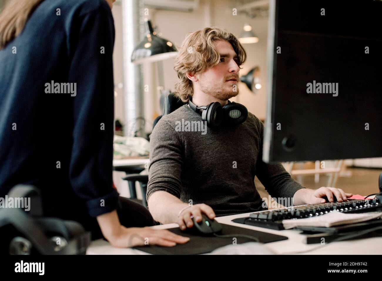 Midsection of entrepreneur with coworker sitting at workplace Stock Photo