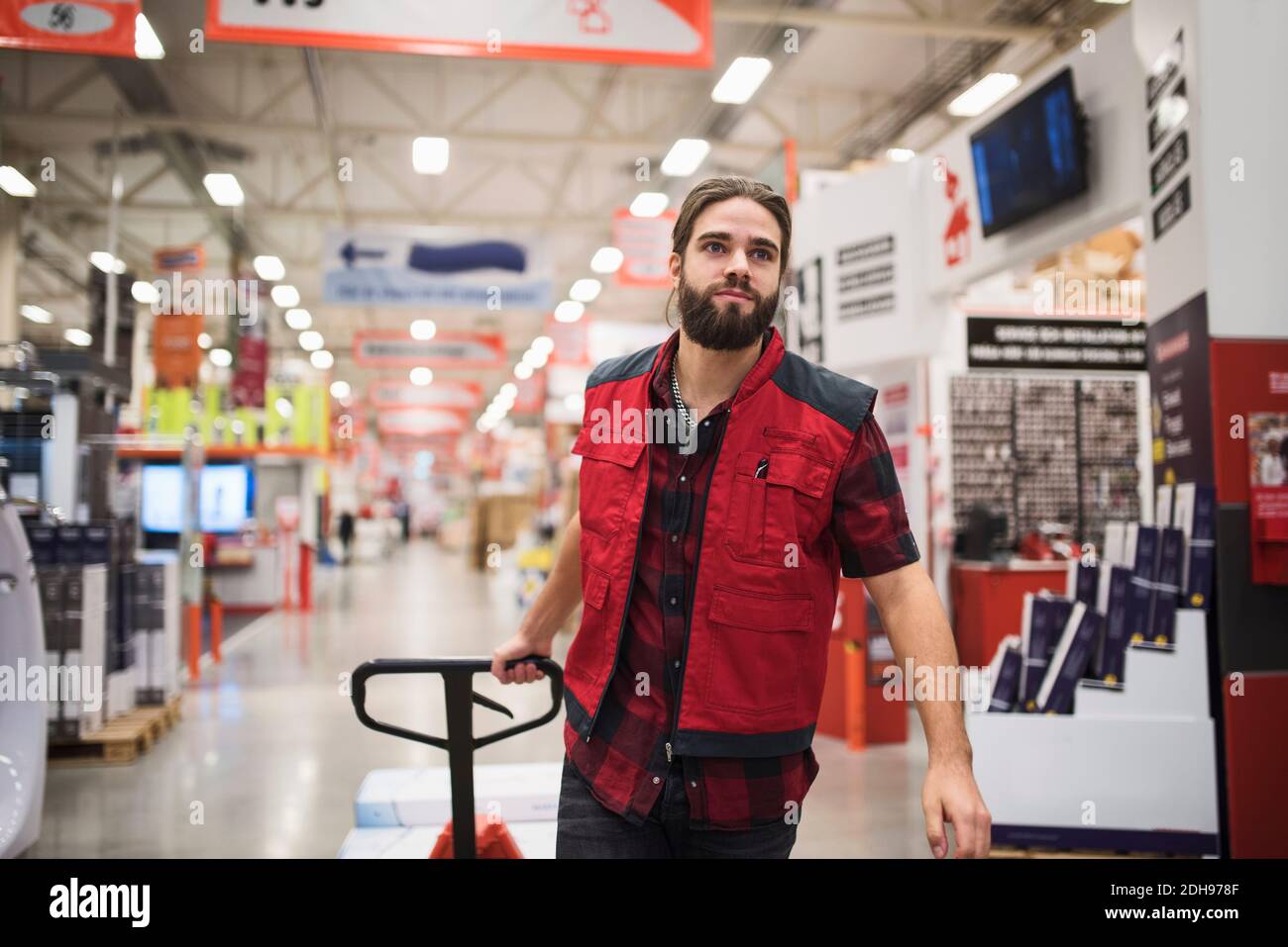 Salesman pulling handtruck in hardware store Stock Photo