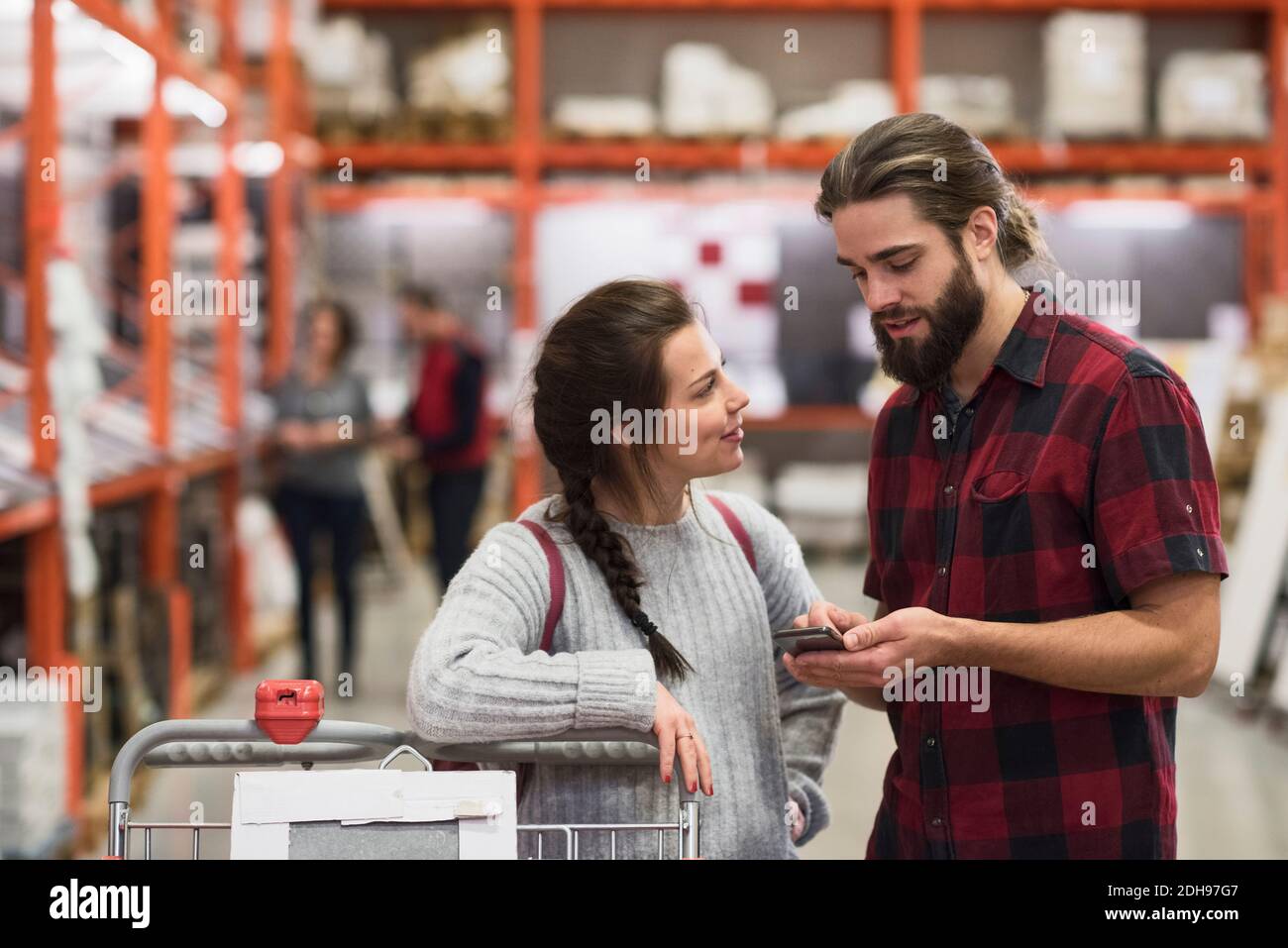 Couple using smart phone in hardware store Stock Photo