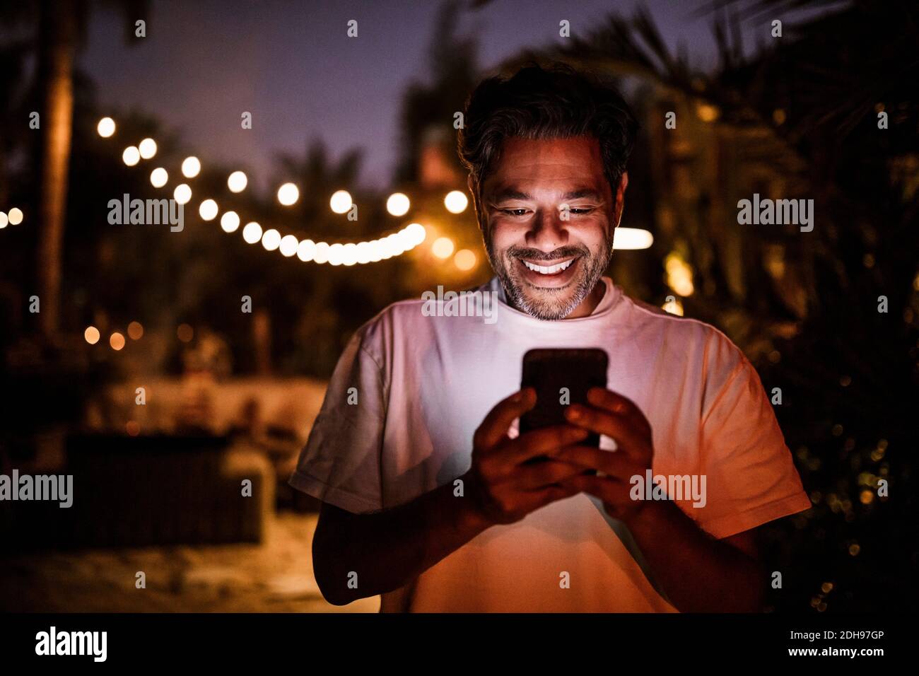 Happy man texting during sunset Stock Photo