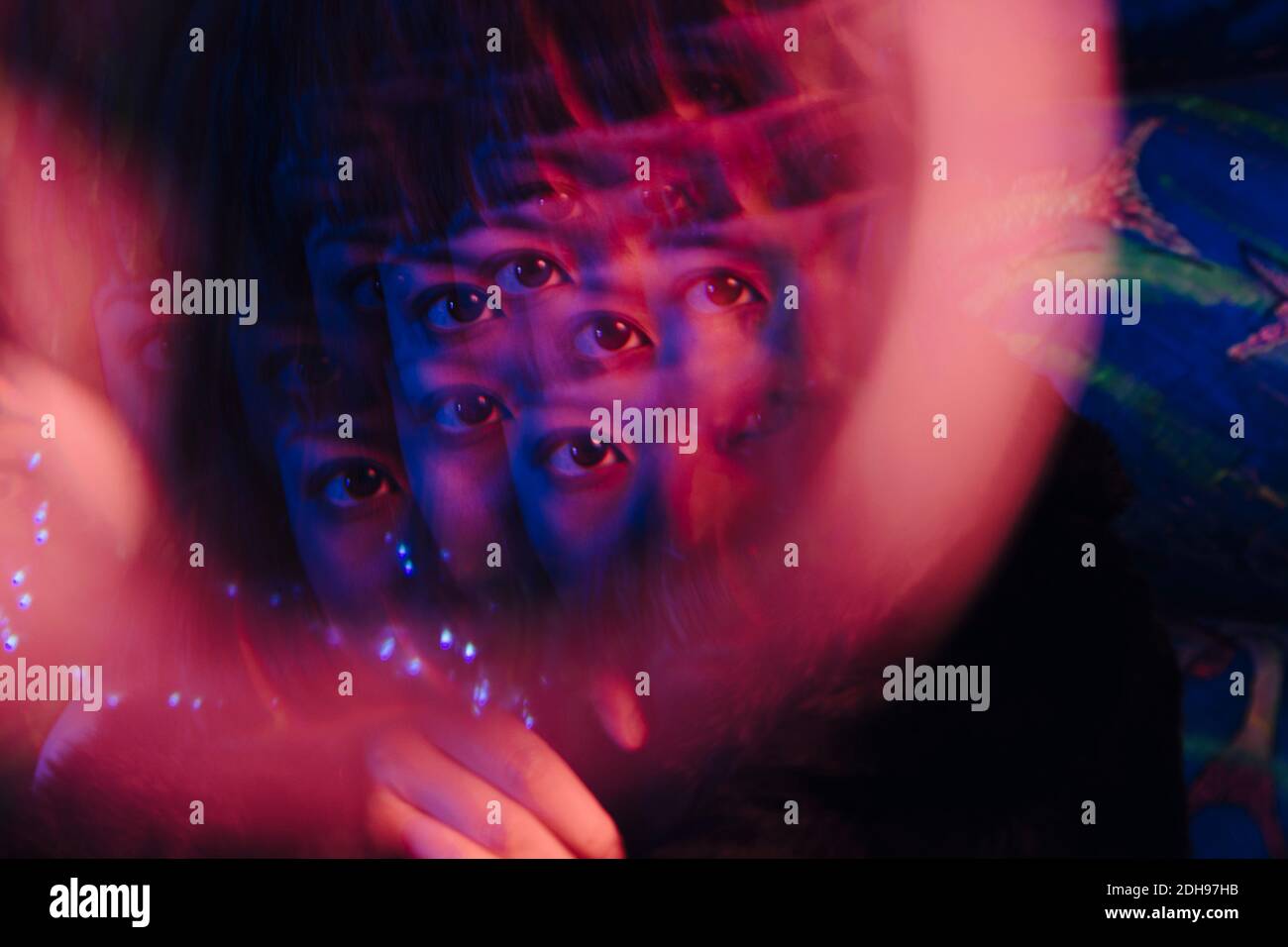 Multiple exposure of woman's eye at illuminated bar Stock Photo