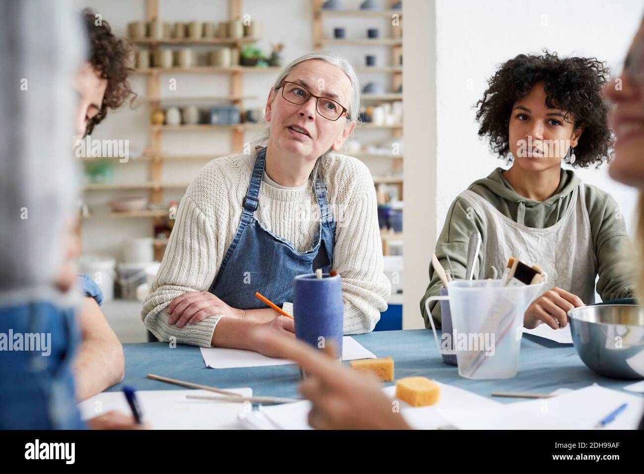 Female students listening sitting at table in art class Stock Photo
