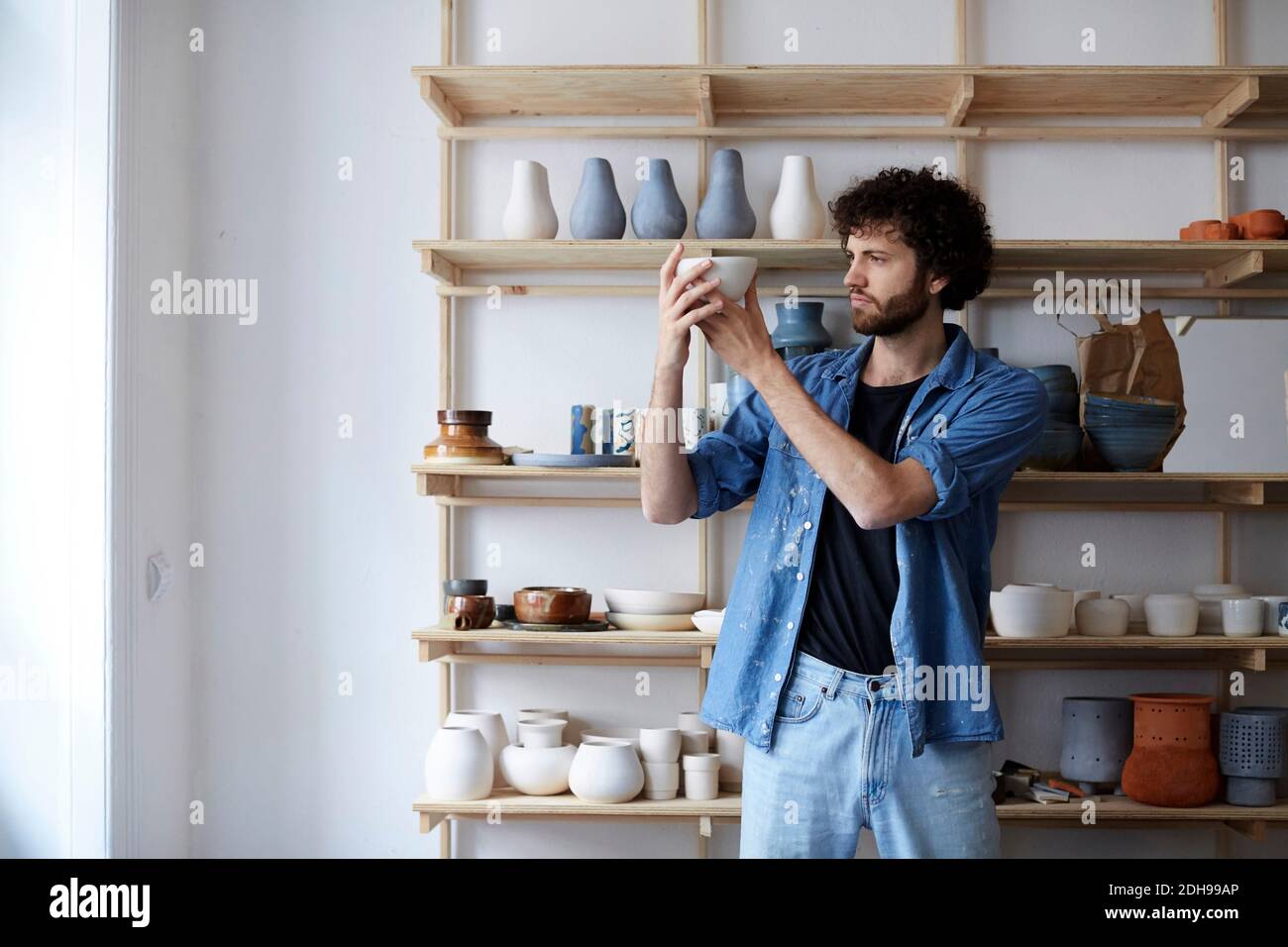 Mid adult man making earthenware in art studio Stock Photo