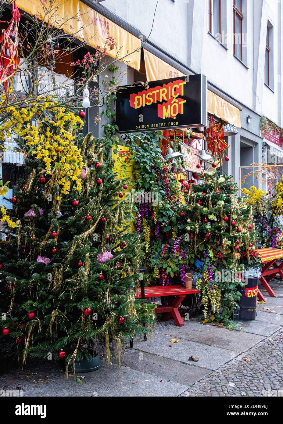 District mot restaurant with Colouful Christmas tree on pavement. Kleine Rosenthaler Strasse, Mitte, Berlin Stock Photo
