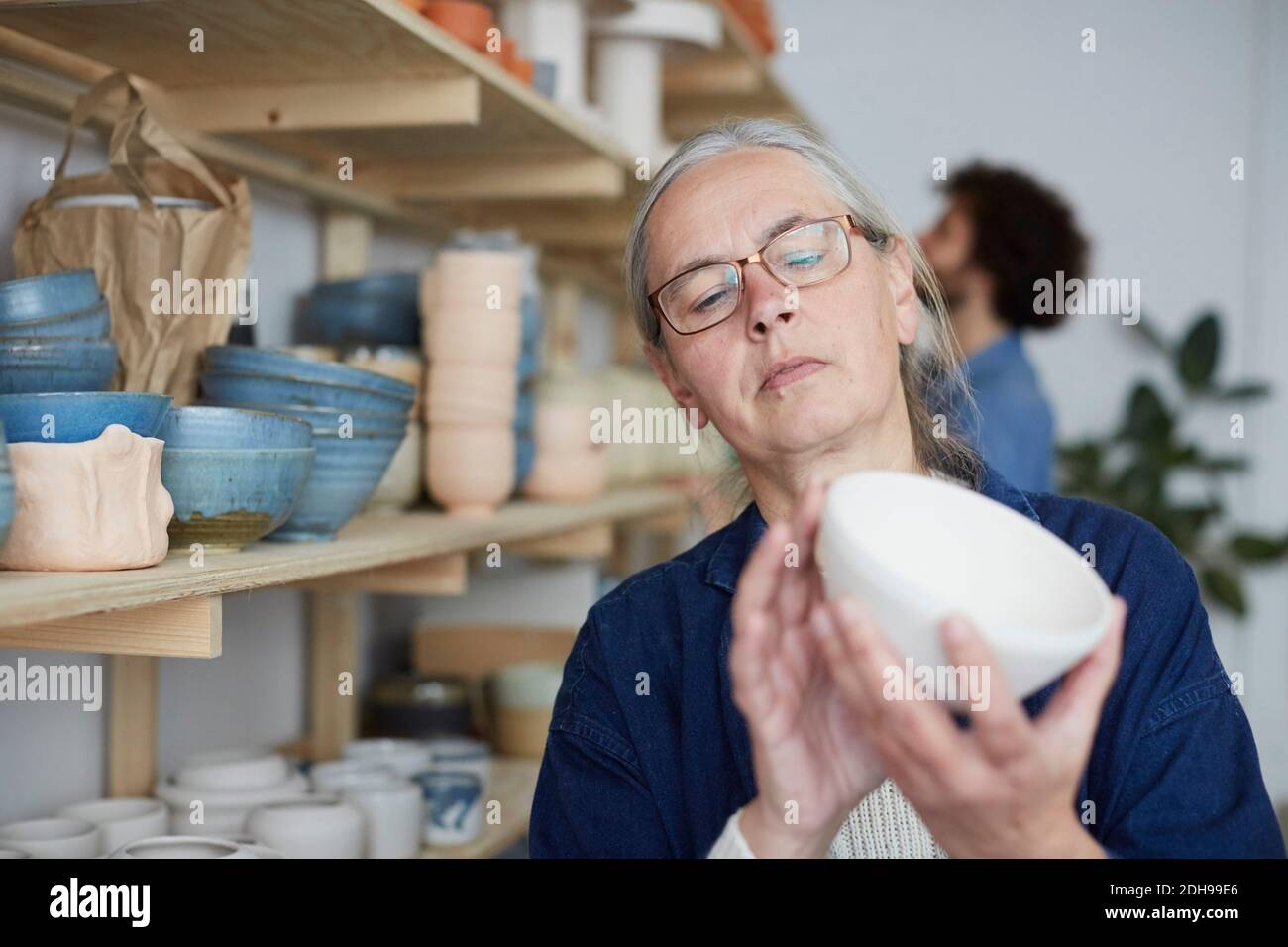 Mature woman examining bowl in art class Stock Photo
