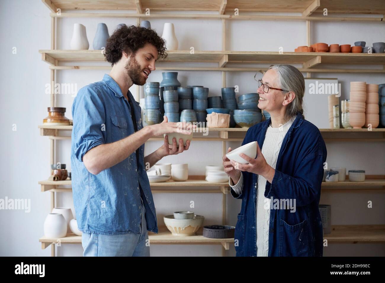 Man and woman discussing over bowl in pottery class Stock Photo