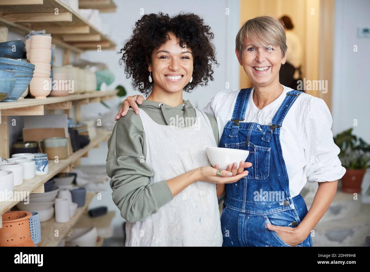 Portrait of smiling females with bowl in pottery class Stock Photo