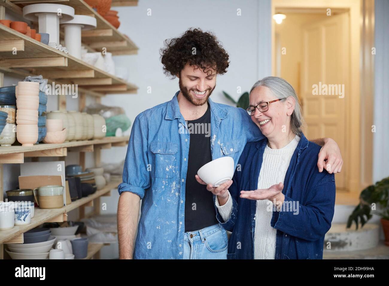Smiling man and woman looking at bowl in pottery class Stock Photo