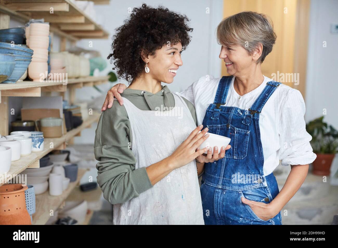 Smiling females with bowl in pottery class Stock Photo
