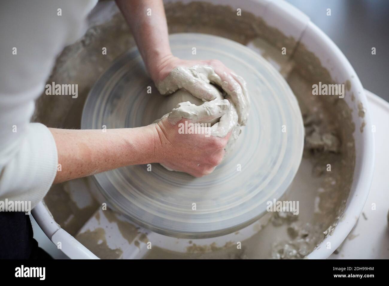 Cropped hands of woman molding pot in pottery class Stock Photo