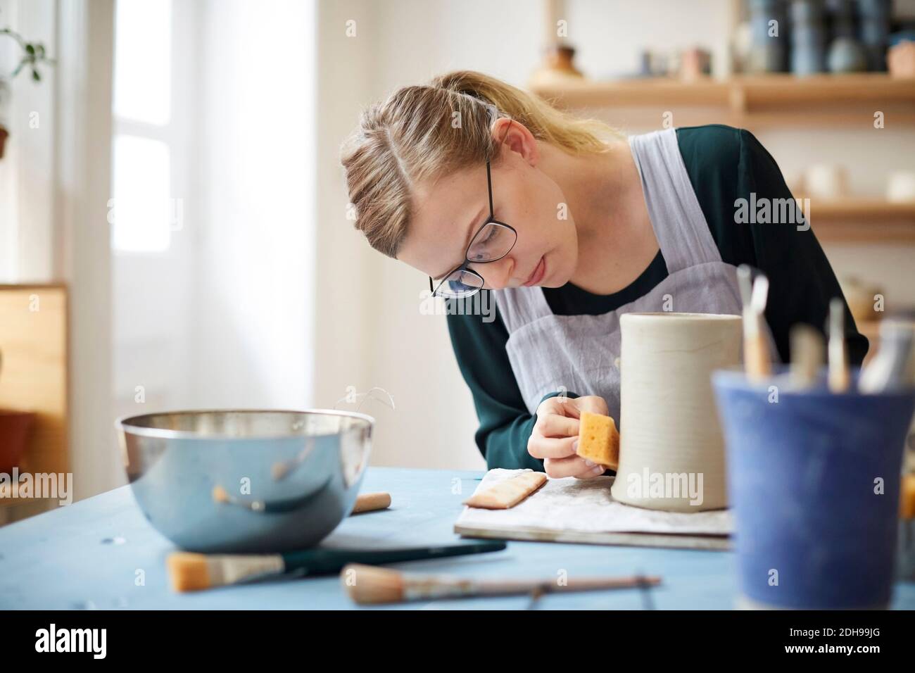 Young woman molding pot in pottery class Stock Photo