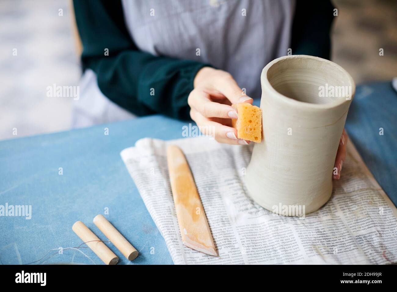 Midsection of young woman molding earthenware at table in art studio Stock Photo