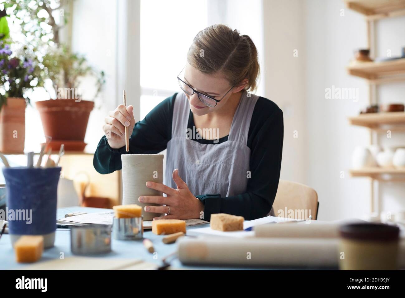 Young woman making earthenware in pottery class Stock Photo