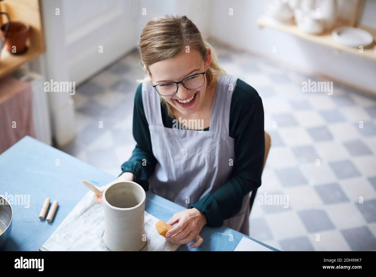 High angle view of smiling woman learning pottery in art class Stock Photo