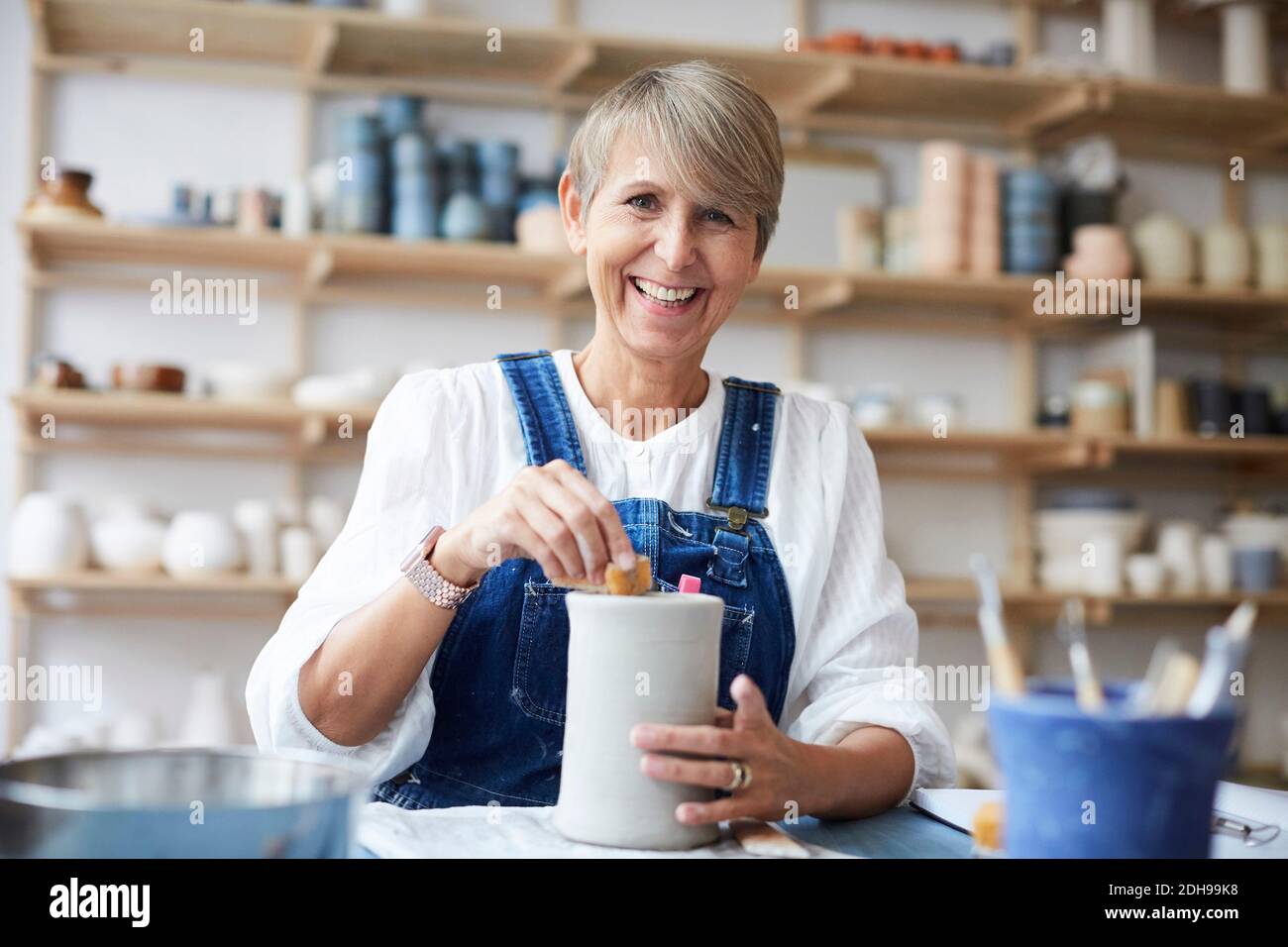 Portrait of smiling mature woman learning pottery in art studio Stock Photo