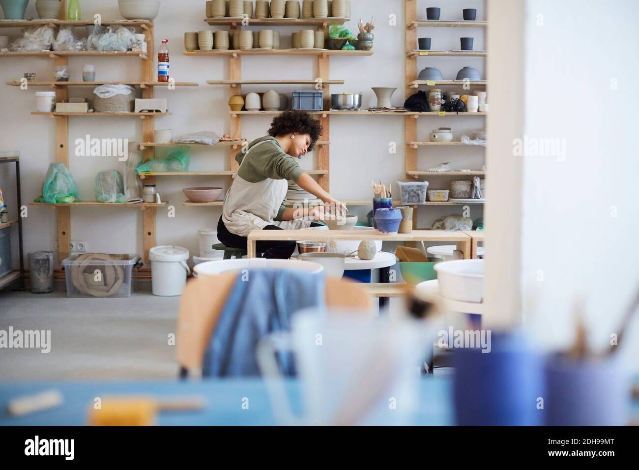 Side view of woman learning pottery in art studio Stock Photo