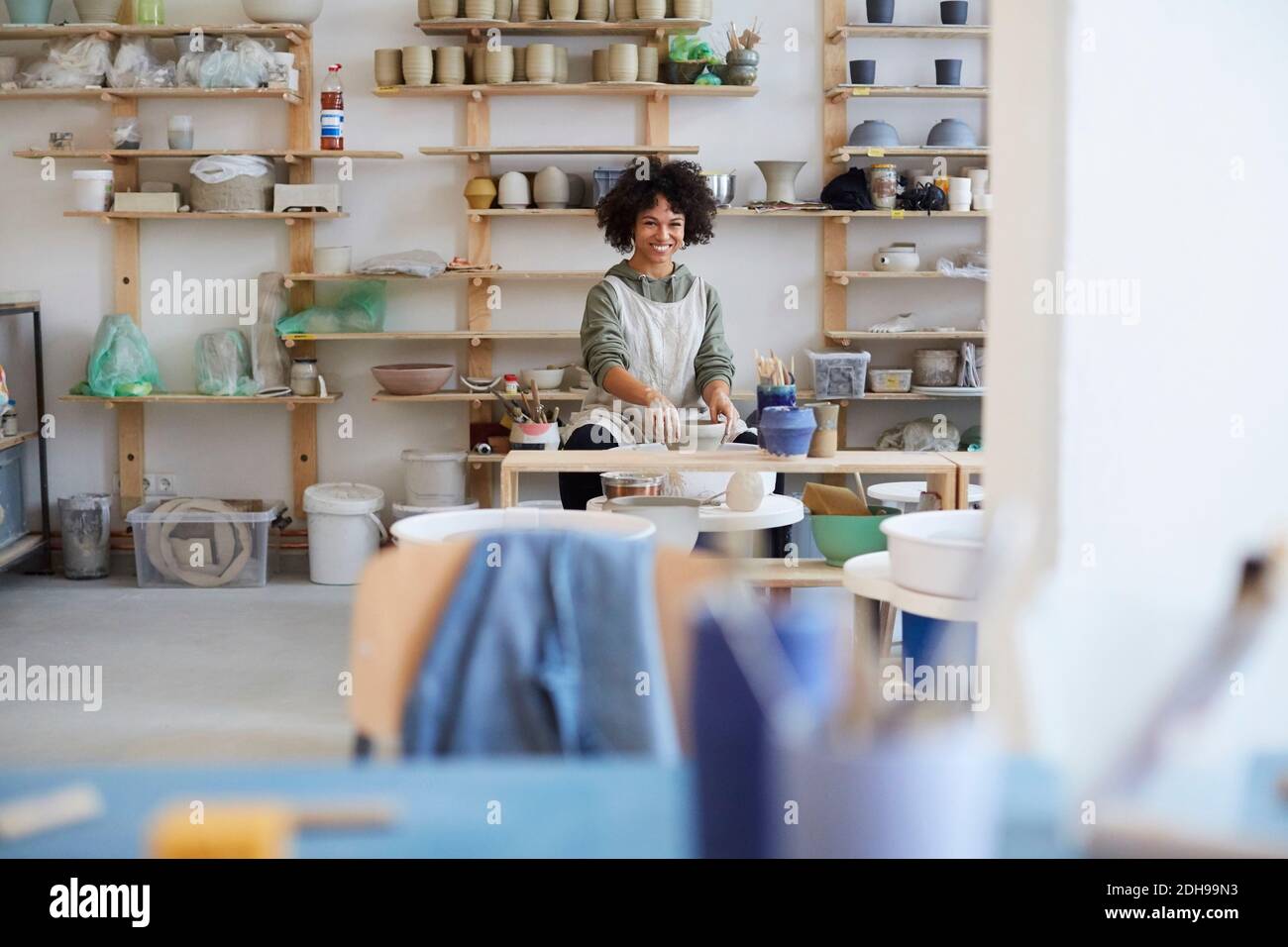 Portrait of smiling woman learning pottery in art studio Stock Photo